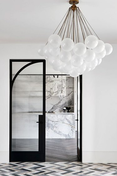 Art deco door with black linear detailing and bubble chandelier