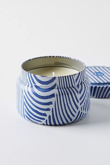 light candle in blue patterned tin