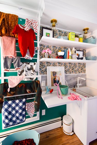 basement laundry room ideas with cool vintage art and clothes on a drying rack.