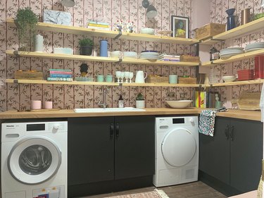 basement laundry room ideas with washer and dryer and patterned wallpaper.