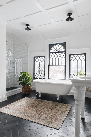 traditional home decor in bathroom with clawfoot tub and decorative windows