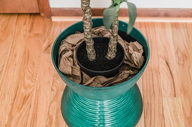 Place a faux potted plant in the center of the planter and fill around it with scrap paper or packing peanuts.