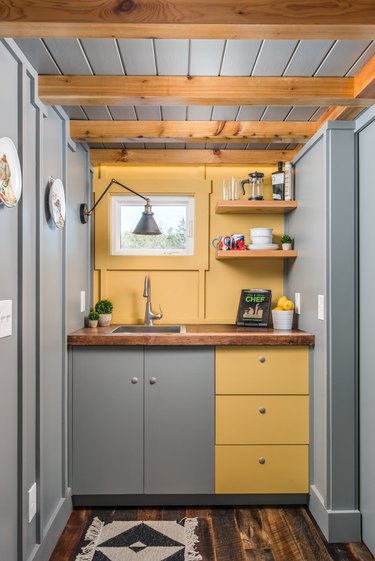 modern tiny house with yellow and gray kitchenette