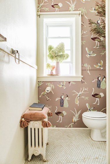 mural on pink wall in small maximalist bathroom with penny tile floor