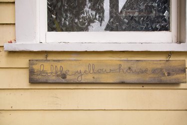 Outside of yellow house with sign