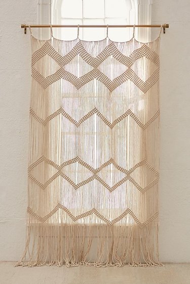 bathroom curtain idea with beige macrame wall hanging used in place of a curtain