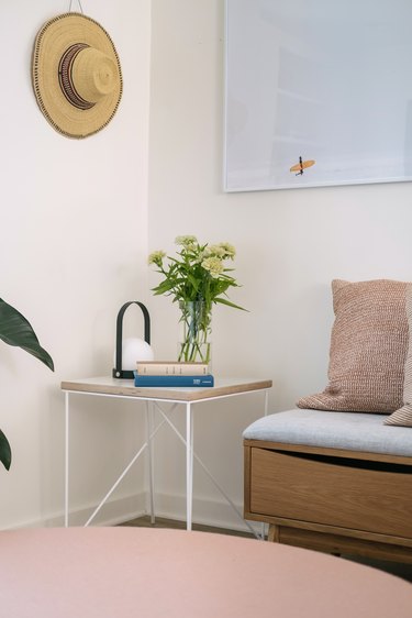 Minimalist living room with blue artwork and pink pastel table with calming colors.