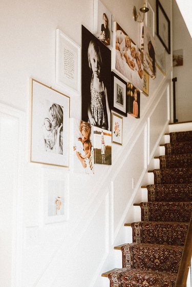 Stairs with carpet runner and gallery wall of family photos