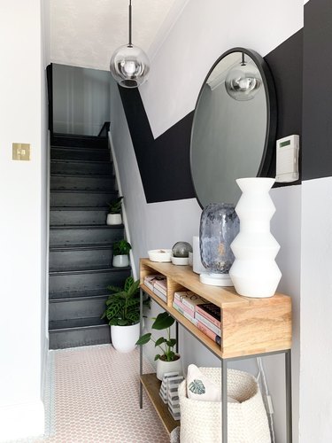 Black stairs with color-blocked black painted stripe on wall