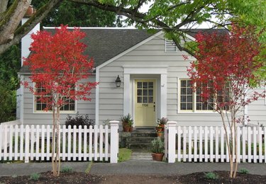 gray traditional home exterior with a white picket fence
