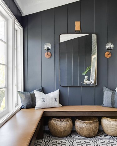 Rustic blue entryway with wood bench and square mirror