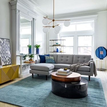 living room space with blue rug and gray couch