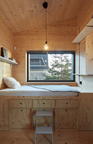Plywood bunk bed with drawer storage, plywood paneling, pendant lights and open shelves. Basement Bedroom Ideas
