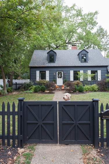 traditional home exterior idea of a dark house with white shutters on the window