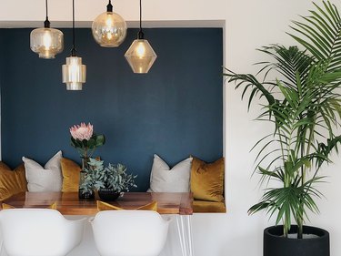 colors that go with blue, dining nook with blue accent wall and gold velvet bench and pillows