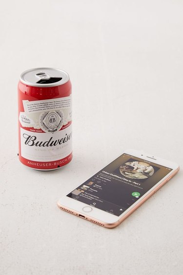 bluetooth speaker in the shape of a beer can near phone