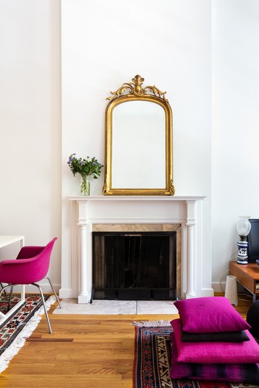 white traditional fireplace with gold mirror on the mantel