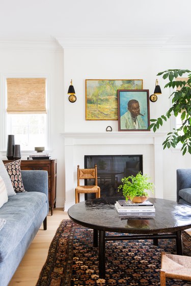 white living room with white traditional fireplace and coffee table with art on the mantel