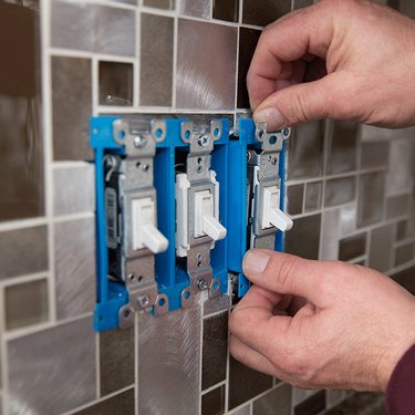 Electrical switches on tile wall.