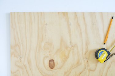 Marking drill holes on plywood sheet