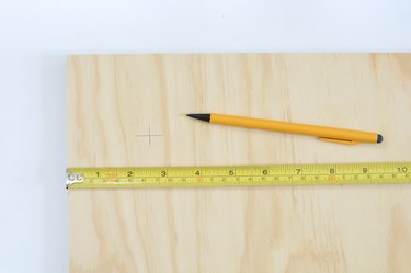 Plywood sheet with tape measure and pencil