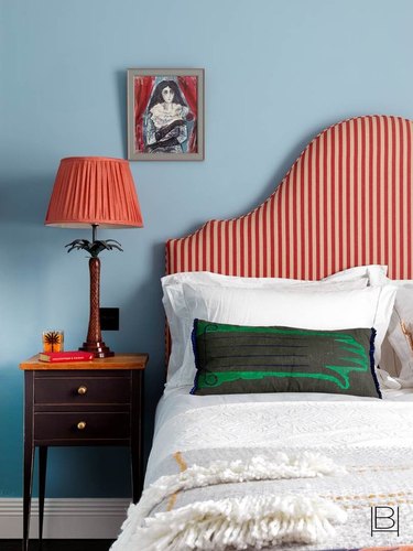 blue paint color in bedroom with red headboard and white bedding