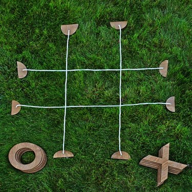 Tic tac toe parts spread out in the grass