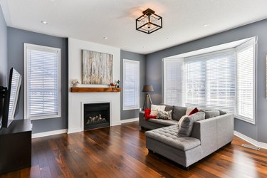 Gray living room with white fireplace and blinds for bay window curtains