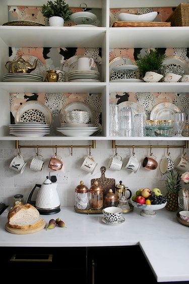 maximalist kitchen with black cabinets and white countertops and open shelving