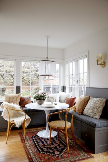 white kitchen with gray linen window bench and small table