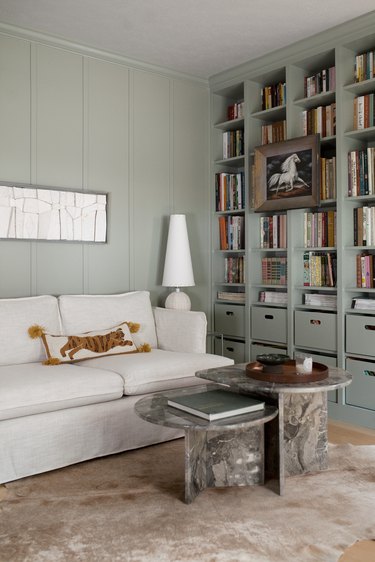 Modern den with sage color walls and bookshelf