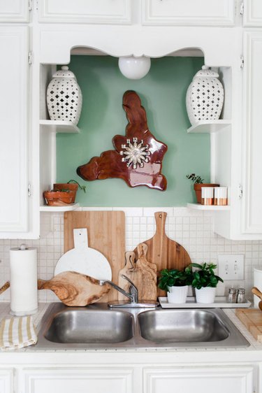 Vintage kitchen with white cabinets and painted sage color alcove