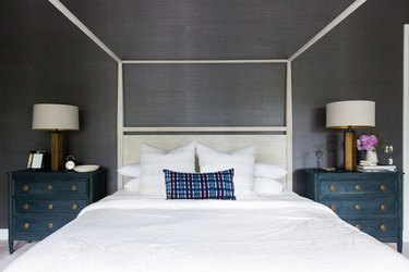 Textured moody bedroom wallpaper idea with canopy bed and blue nightstands