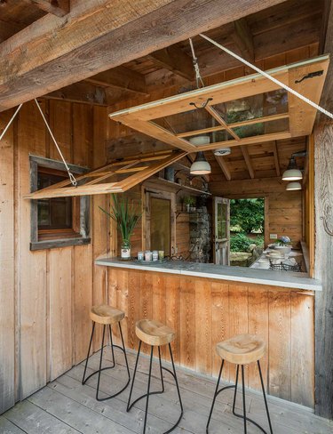 rustic outdoor kitchen with bar stools and concrete countertop