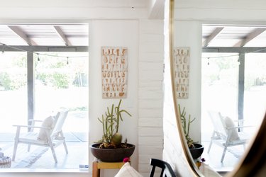 A corner reveals interior adobe walls and a local artist's work.