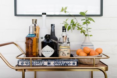 A bar cart set against an adobe wall.