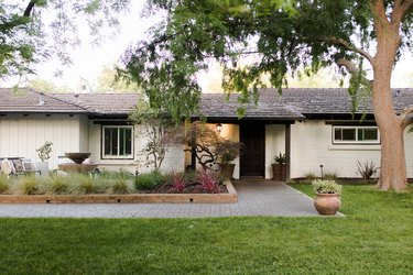 exterior of a house with a front lawn and tree