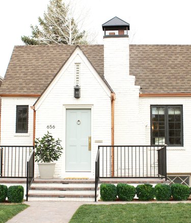 white brick tudor with mint green front door