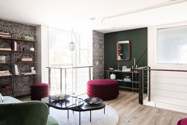 jewel-tone library with patterned wallpaper and green walls with curved furniture