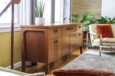 vintage vintage living room idea with sideboard in front of a window in a mid-century living room
