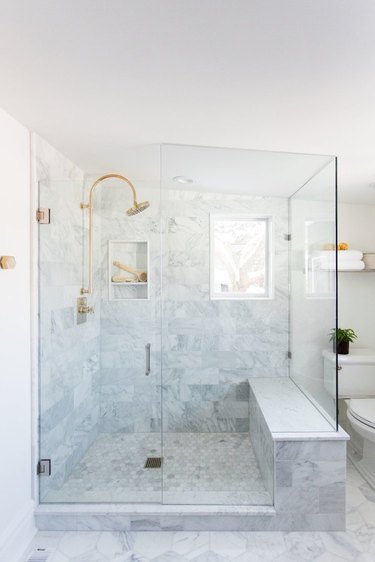 Marble bathroom shower idea with built-in bench and window