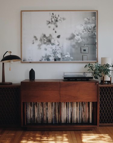vintage living room idea with record cabinet under a framed black and white abstract art prin