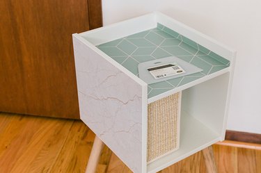 Stick the cut patterned shapes to the top and sides of the IKEA cat house.