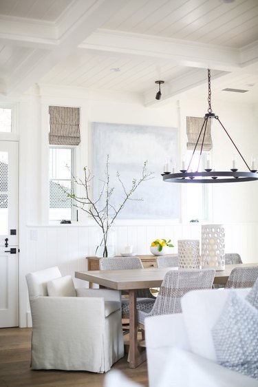 rustic beach decor in dining room with modern black chandelier and wood dining table