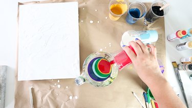 Pouring paint into measuring cup.