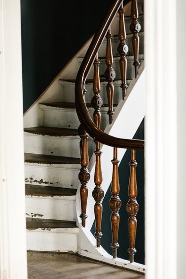Rustic stair railing with curved banister and white steps
