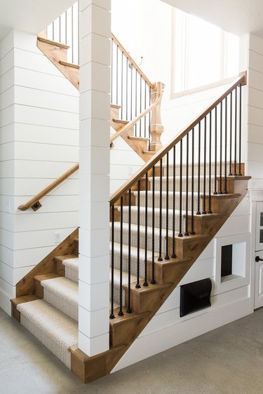 Rustic stair railing with beige stair runner and white shiplap