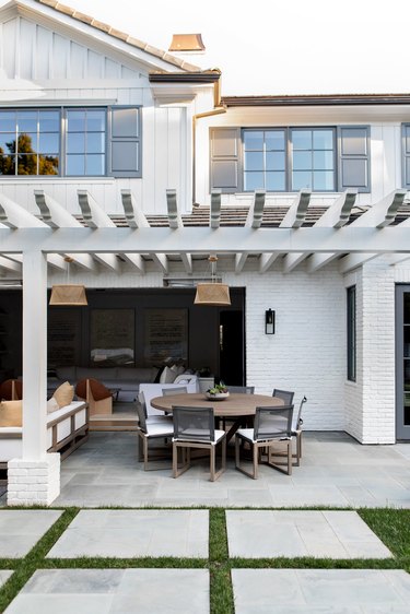 White house with gray exterior window trim and outdoor seating area