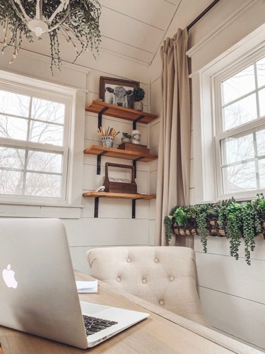 Rustic office with open wood shelving and white shiplap walls