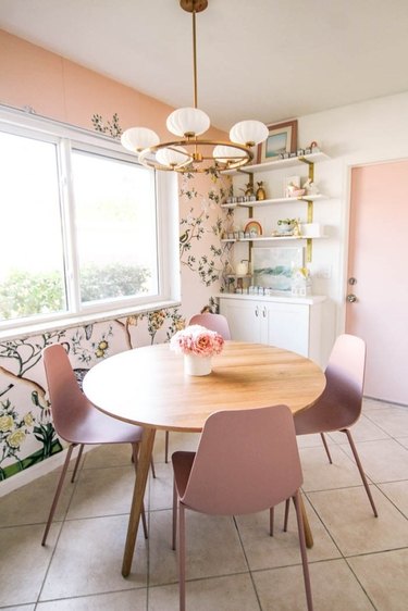 pink dining room with botanical wallpaper print and blush chairs